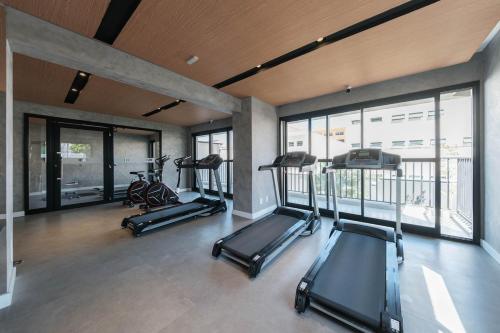 a gym with three treadmills and a row of exercise bikes at Luxurious condo | Budget flat in Sao Paulo
