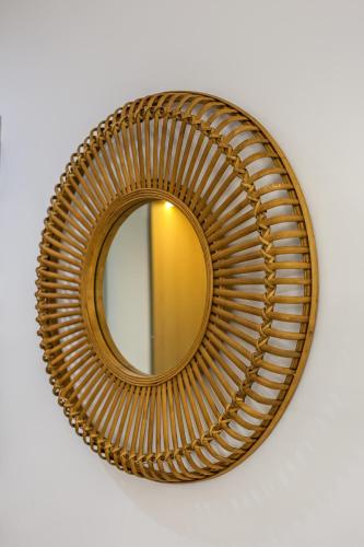 a round gold mirror on a white wall at Villa Cocosinella Belgrade in Surčin