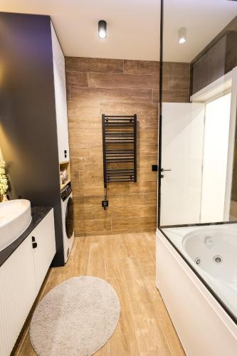 a bathroom with a tub and a toilet and a sink at Villa Cocosinella Belgrade in Surčin