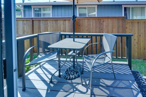 a table and chairs on a balcony with an umbrella at Shared Yard Apt 2 Mi to Port Angeles City Pier in Port Angeles