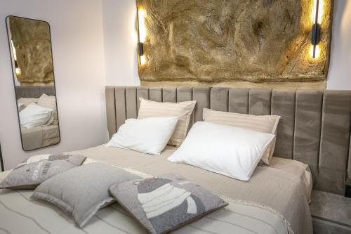 a bed with two pillows and two mirrors at Villa Cocosinella Belgrade in Surčin