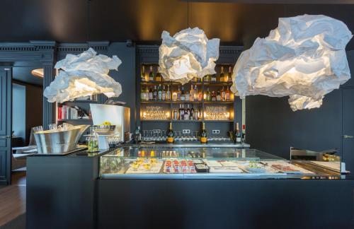 a restaurant with a counter with food and lights at Hôtel La Comtesse in Paris