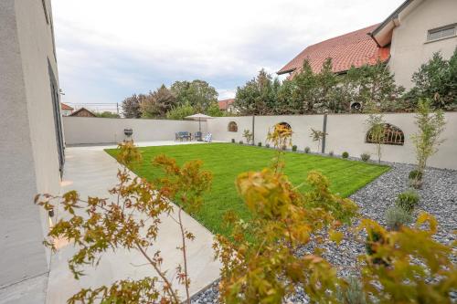 a backyard with a lawn and a fence at Villa Cocosinella Belgrade in Surčin