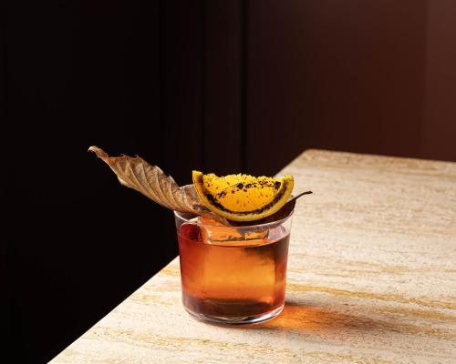 a drink with an orange peel in a glass at Locanda Expanificio in Agrigento