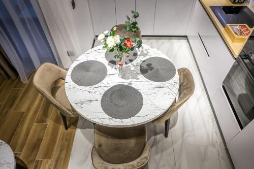 a white table with a vase of flowers on it at Villa Cocosinella Belgrade in Surčin