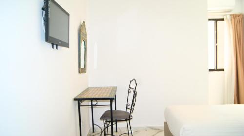 a room with a table and two chairs and a bed at Hotel Nouzha in Fès