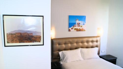 a bedroom with a bed and a picture on the wall at Hotel Nouzha in Fès