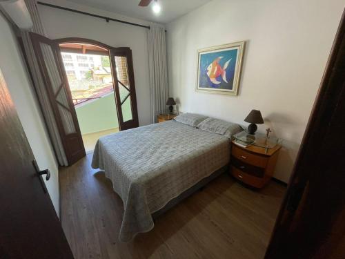 una camera da letto con un letto e una finestra di Cód 9 · Casa aconchegante á 300m do mar! a Governador Celso Ramos