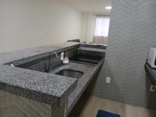 クルーズ・ダス・アルマスにあるFlat Centralのシンクとカウンタートップのあるキッチン
