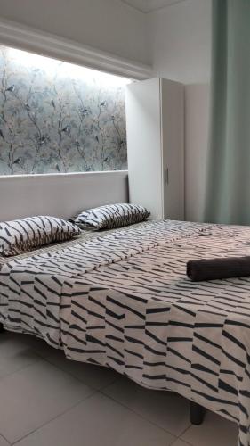 a bedroom with a large bed with a window at La Marina in Alicante