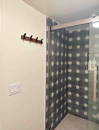 a shower with a glass door in a bathroom at A small room in the backyard with a full bed in Norwalk