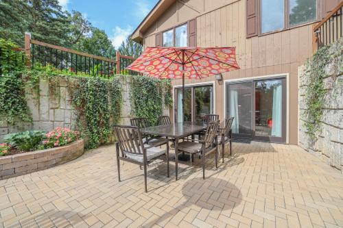 a table with chairs and an umbrella on a patio at Harmony Inn, Huntley Illinois in Huntley