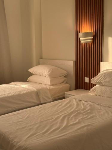 two beds sitting next to each other in a room at ONYX F64-2BHK cozy full furnished in heart of Muscat in Muscat