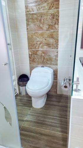 a bathroom with a toilet and a shower at Hotel VILLA CABAÑA in Villagarzón
