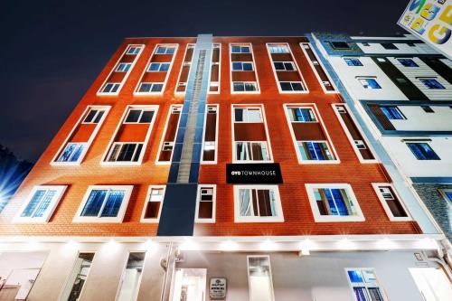 a tall red brick building with a sign on it at Townhouse Ecity Inn in Bengaluru
