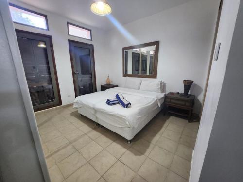 a bedroom with a white bed and a mirror at One bed room at Talabay Aqaba in Aqaba