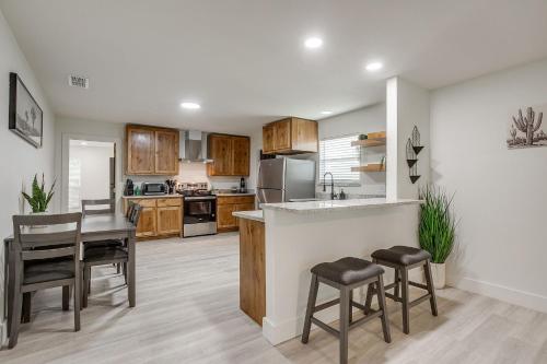 a kitchen with wooden cabinets and a table and chairs at NEW The Round Up, 4BR, Walk to TSU, Downtown in Stephenville