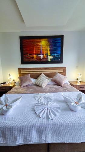 a bedroom with a large bed with a painting on the wall at Hotel VILLA CABAÑA in Villagarzón