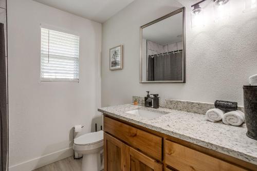 a bathroom with a sink and a toilet and a mirror at NEW The Round Up, 4BR, Walk to TSU, Downtown in Stephenville