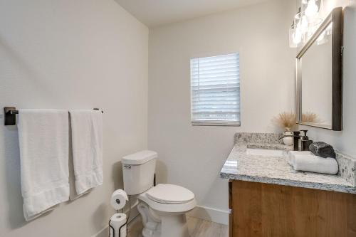 a white bathroom with a toilet and a sink at NEW The Round Up, 4BR, Walk to TSU, Downtown in Stephenville