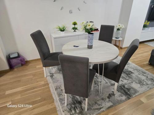 a dining room table with four chairs and a table at AiM apartman Bjelasnica in Bjelašnica