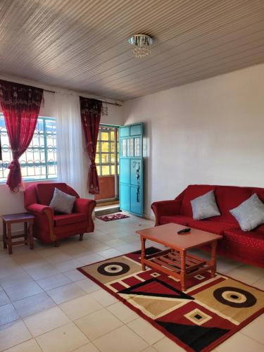 a living room with two red couches and a table at IBL Apartments in Machakos