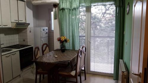 a kitchen with a table with chairs and a window at Spacious and Bright 2BR Apartment near City Center in Skopje
