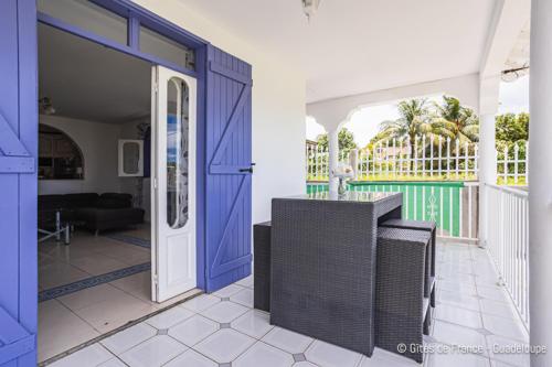 a house with a blue door and a porch at Villa B&M in Les Abymes