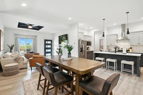 a kitchen and living room with a wooden table and chairs at Brand New Cool Comfy Lawrence Retreat Duplex in Lawrence