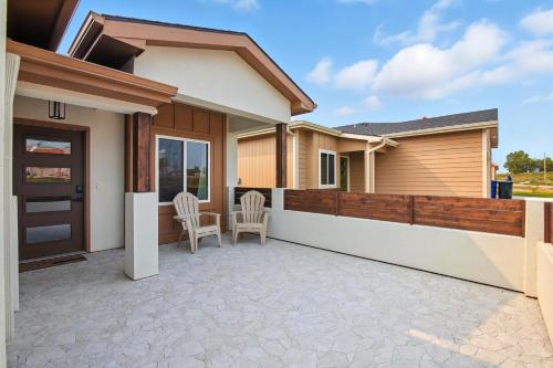 a house with a patio with two chairs at Brand New Cool Comfy Lawrence Retreat Duplex in Lawrence