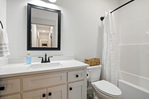 a bathroom with a sink and a toilet and a mirror at Brand New Cool Comfy Lawrence Retreat Duplex in Lawrence