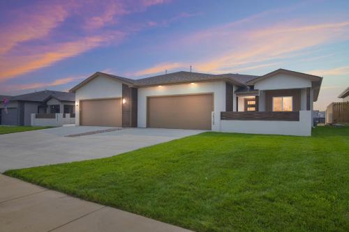 a house with a garage in a yard at Brand New Cool Comfy Lawrence Retreat Duplex in Lawrence