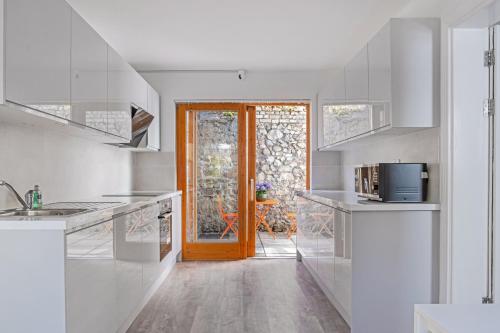 a kitchen with white counters and a door to a patio at Eblana House in Dublin