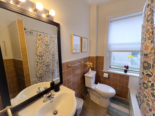 a bathroom with a sink and a toilet and a window at Byward Market Downtown Guesthouse in Ottawa