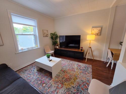 a living room with a couch and a tv at Byward Market Downtown Guesthouse in Ottawa