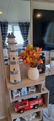 a table with a vase of flowers and a toy train at Sea view holiday home with accessible ramp and WiFi in Port Seton