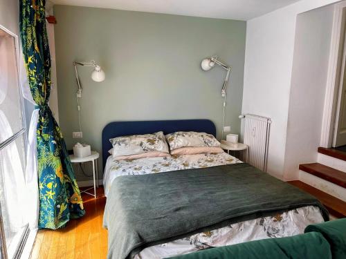 a bedroom with a bed with a blue headboard and two lamps at 30 Seconds from Pantheon Walk Everywhere in Rome