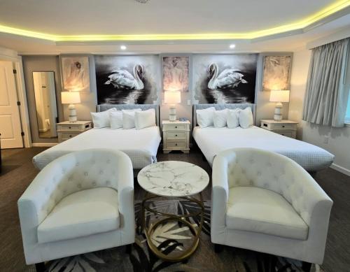 a hotel room with two beds and two chairs at Island House Resort Hotel in St Pete Beach
