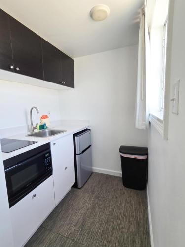 a white kitchen with a sink and a dishwasher at Island House Resort Hotel in St. Pete Beach