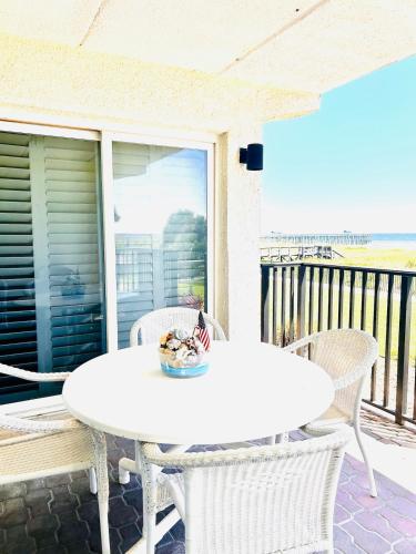 a white table and chairs on a patio at The Seahorse, a 2bed beach paradise in Fernandina Beach, swimming pool! in Fernandina Beach