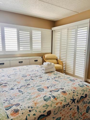 a bedroom with a large bed and a chair at The Seahorse, a 2bed beach paradise in Fernandina Beach, swimming pool! in Fernandina Beach