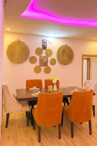a dining room with a table and orange chairs at New build house with garden Lomé in Lomé