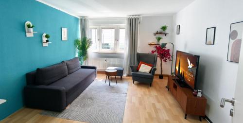 a living room with a couch and a tv at Zentrale Stadtwohnung mit Küche - WIFI I City Centre with Kitchen in Ulm