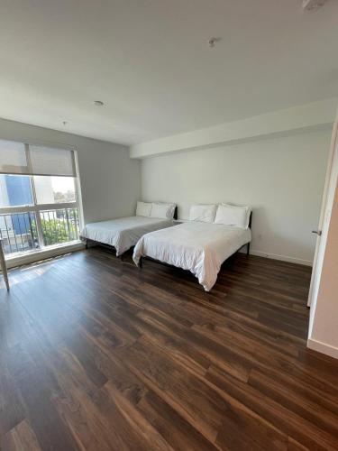 a bedroom with two beds and a large window at Cozy Loft Sunset FRRE WIFI and DESIGNATED Parking in Los Angeles
