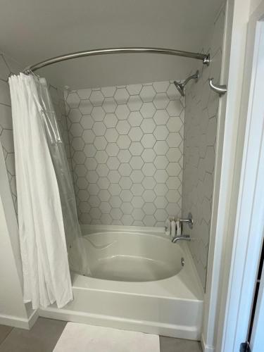 a white bath tub in a bathroom with a shower at Cozy Loft Sunset FRRE WIFI and DESIGNATED Parking in Los Angeles