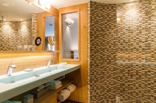 a bathroom with a sink and a shower at Das Freiberg Romantikhotel in Oberstdorf
