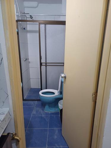 a bathroom with a toilet and a blue tile floor at Jenny luna in Sabaneta