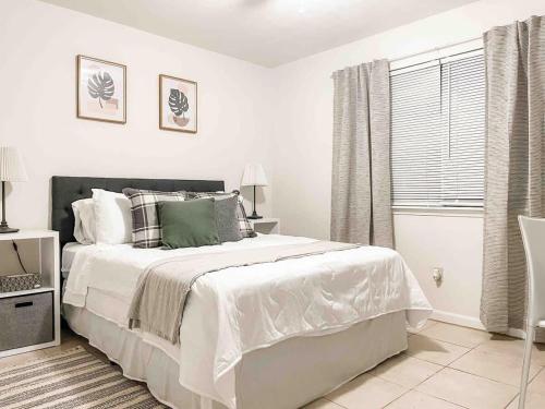 a white bedroom with a bed and a window at Serene Private Two Bedroom Townhouse in East TLH in Perkins