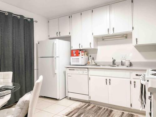 a kitchen with white cabinets and a white refrigerator at Serene Private Two Bedroom Townhouse in East TLH in Perkins