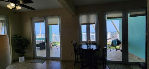 a living room with a table and glass doors with a balcony at Hidden Gem of Puerto Rico in Patillas